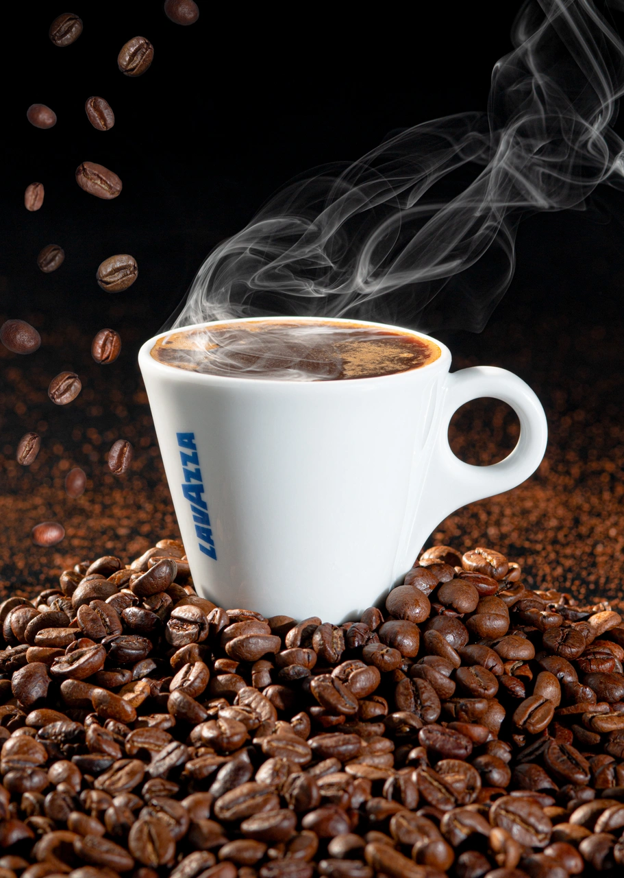 Tassa de cafè Lavazza amb vapor i grans de cafè.